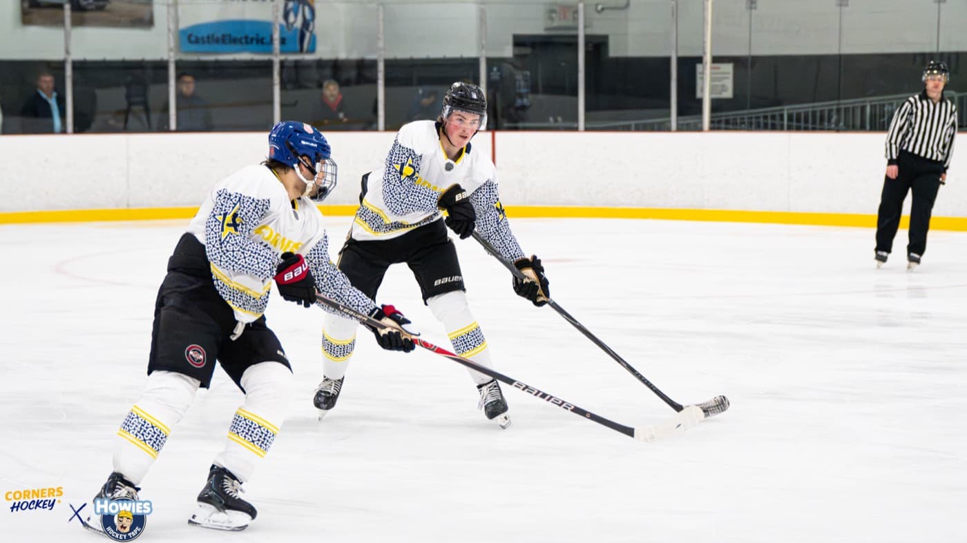 Two Corners Hockey players competing for a loose puck at the blue line