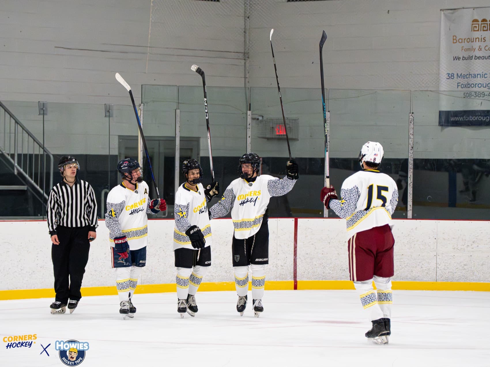 A line of Corners Hockey players celebrating a goal along the boards
